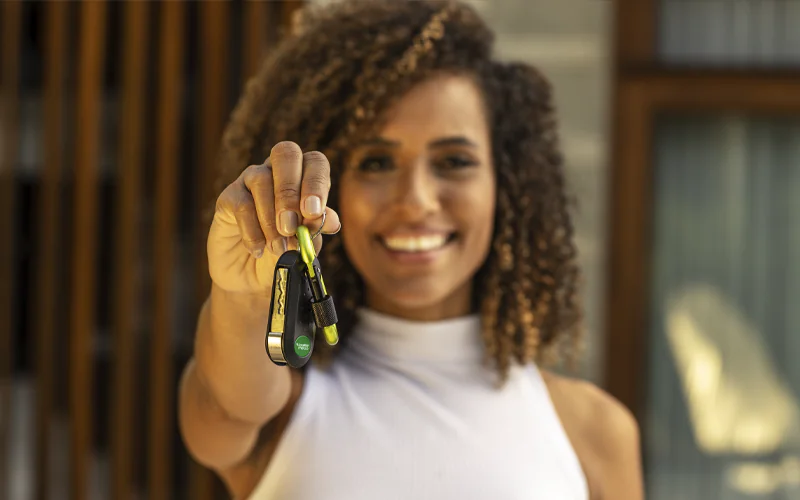 Imagem de uma mulher segurando a chave de um carro