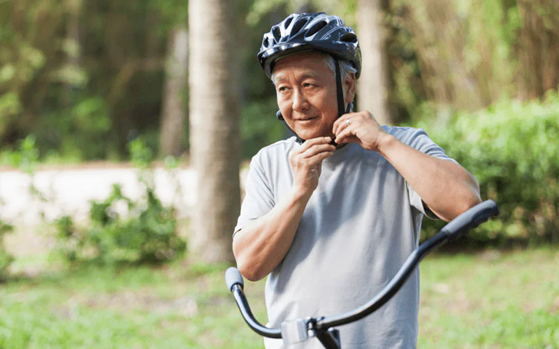 Um senhor se preparando para andar de bicicleta.