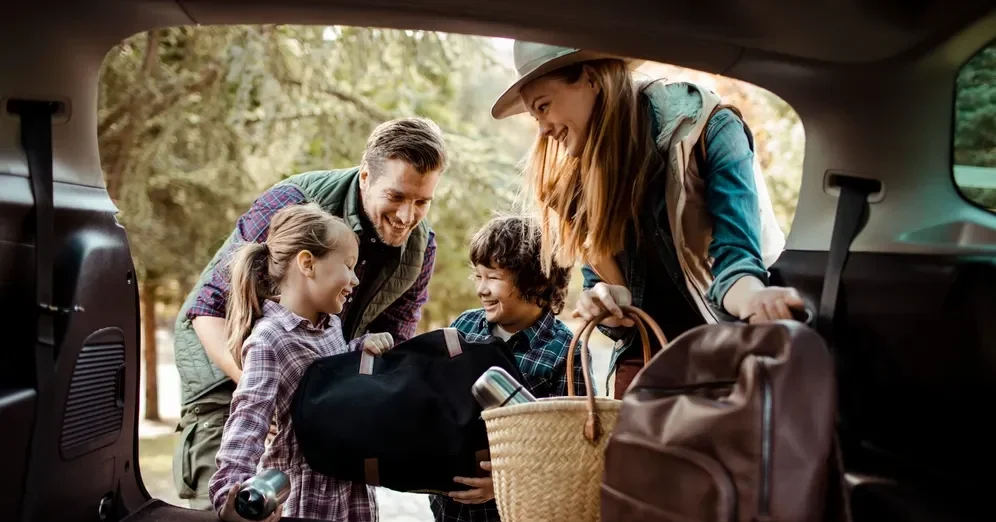 Imagem de uma família se preparando para viajar em um carro espaçoso