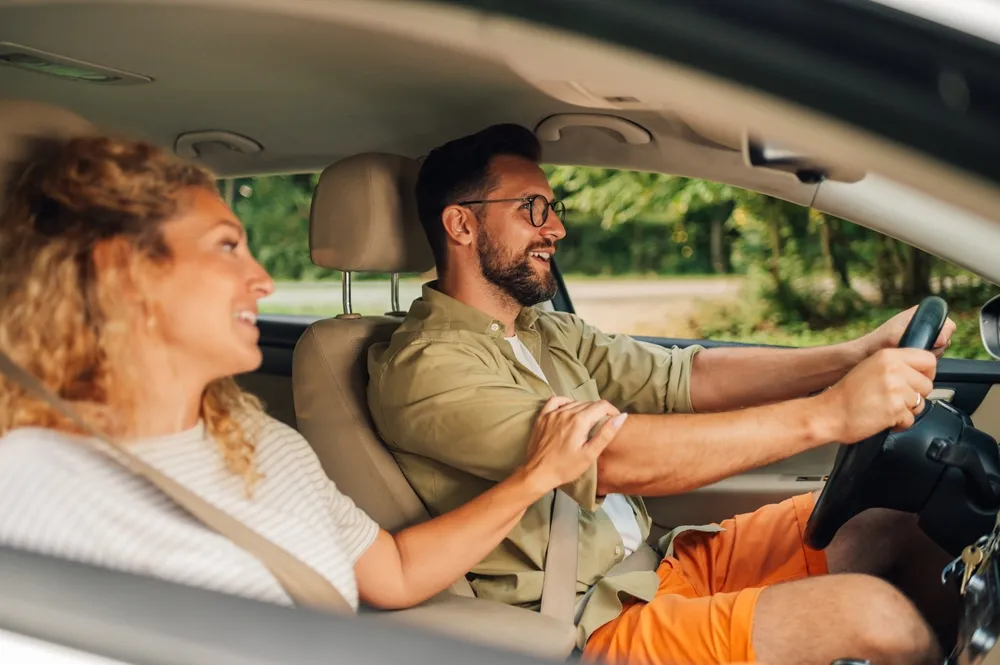 Carro hatch automático: opções para dirigir com mais conforto Imagem de um casal em um carro hatch automático