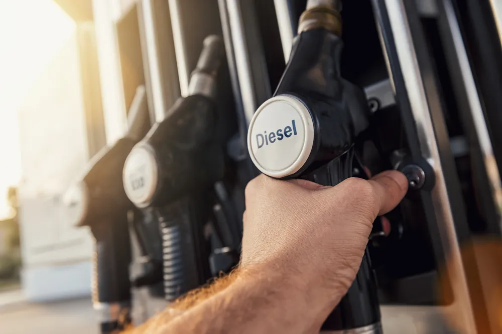 Imagem de uma pessoa no posto de gasolina abastecendo um carro a diesel