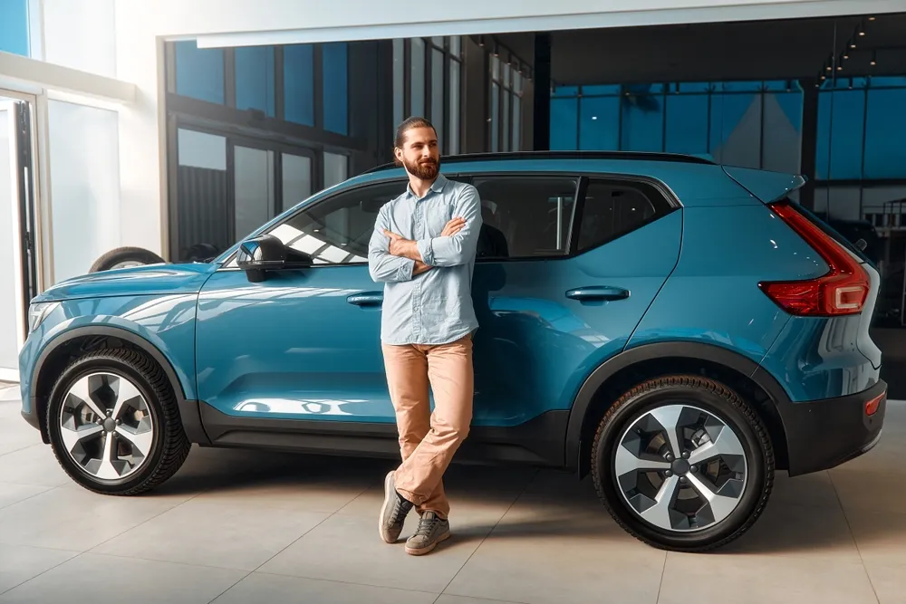 Como consultar a Tabela FIPE: Imagem de uma pessoa com o seu carro novo