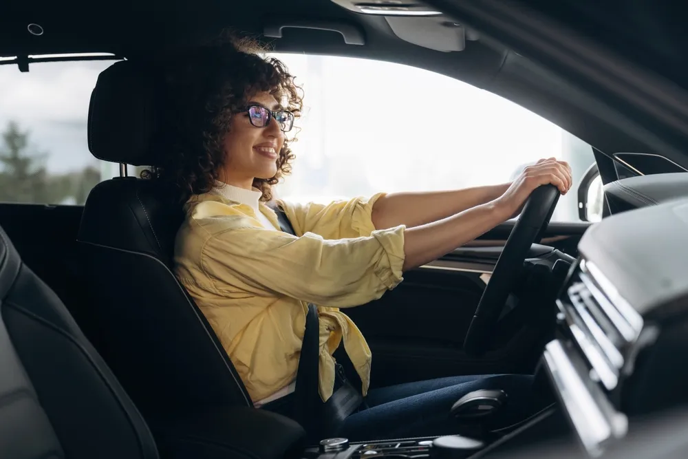 Preço de carro por assinatura: imagem de uma pessoa dirigindo seu automóvel zero.