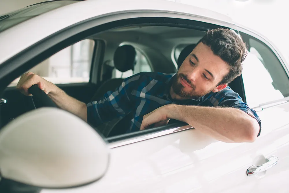 Imagem de pessoa dirigindo um carro representando um SUV cupê