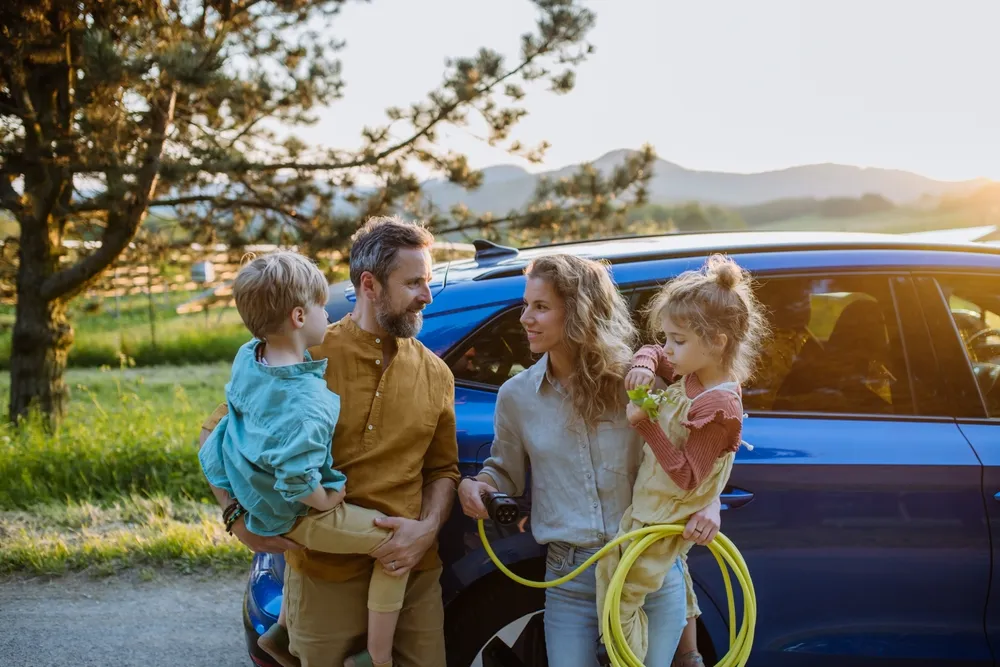 Imagem de uma família recarregando um tipo de carro híbrido