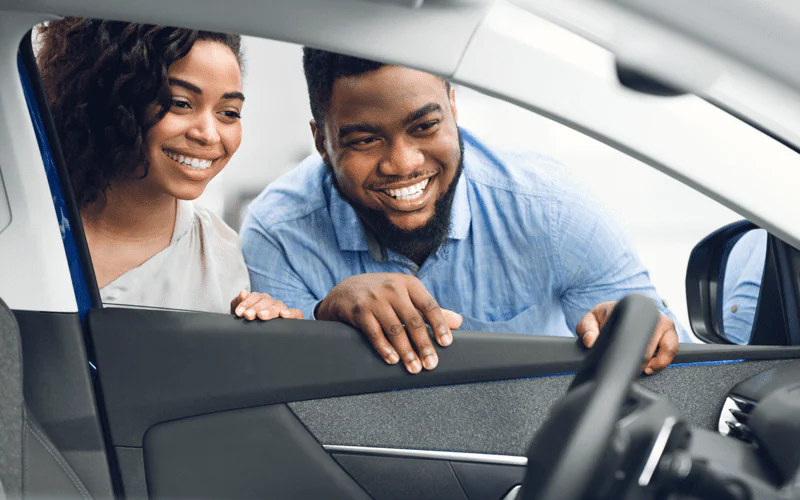 homem e mulher olhando o carro pela janela