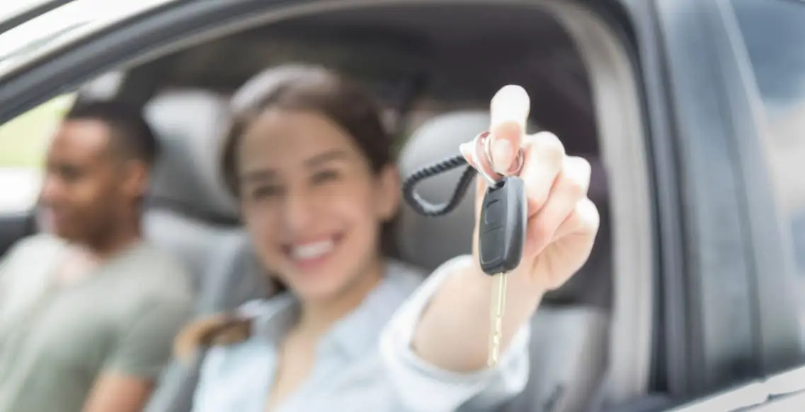 Mulher segurando chave do carro provisório