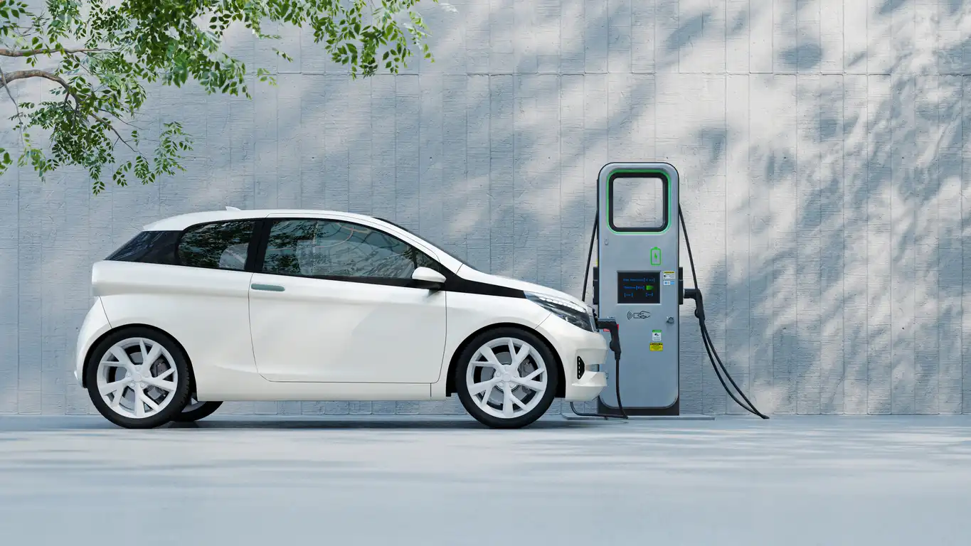 Carro elétrico branco conectado a uma estação de carregamento em ambiente urbano, destacando a tecnologia de veículos elétricos no contexto de sustentabilidade automotiva.