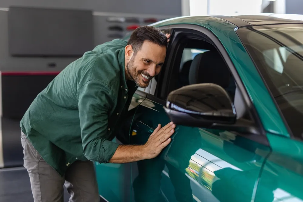 Carro por assinatura: como funciona? Entenda aqui Pessoa sorrindo com o seu carro por assinatura