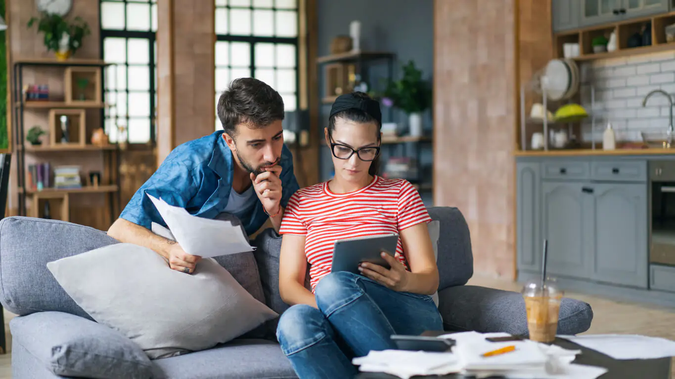 Casal analisando investimentos para se proteger da inflação