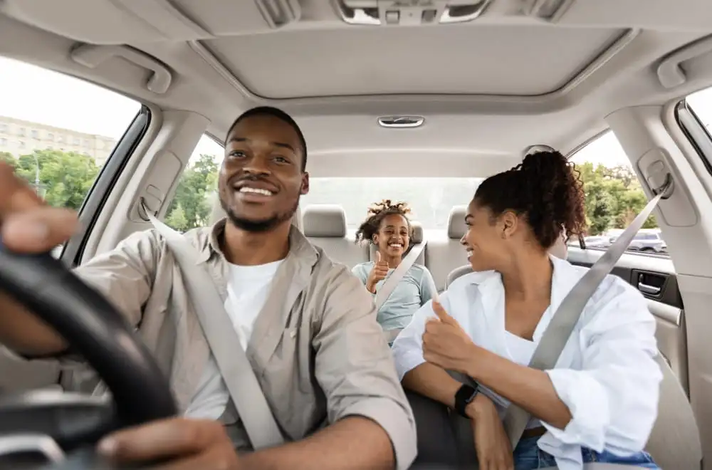 Imagem de uma família comemorando a compra do primeiro carro