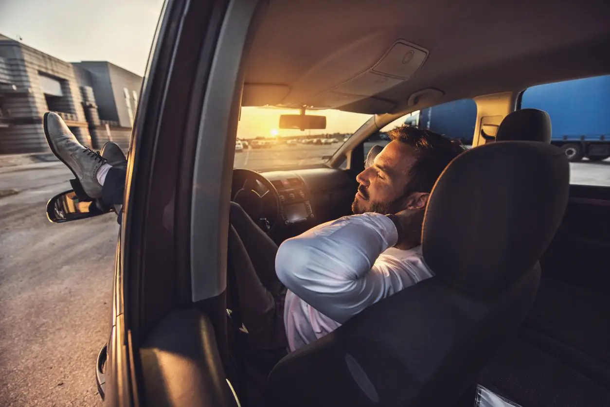 homem aproveitando o seu carro para descansar